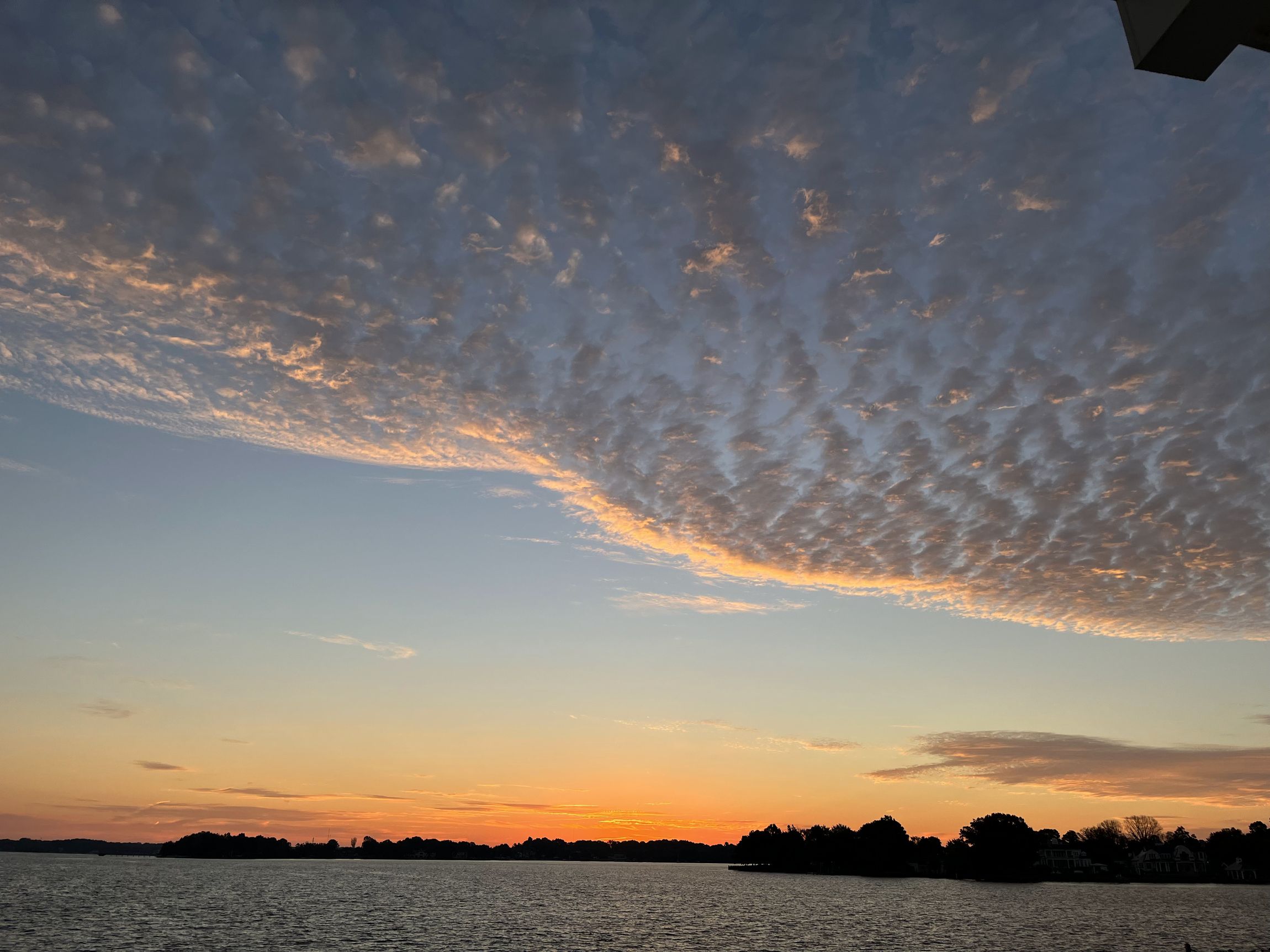 Rippled clouds lit gold over Lake Norman at sunset